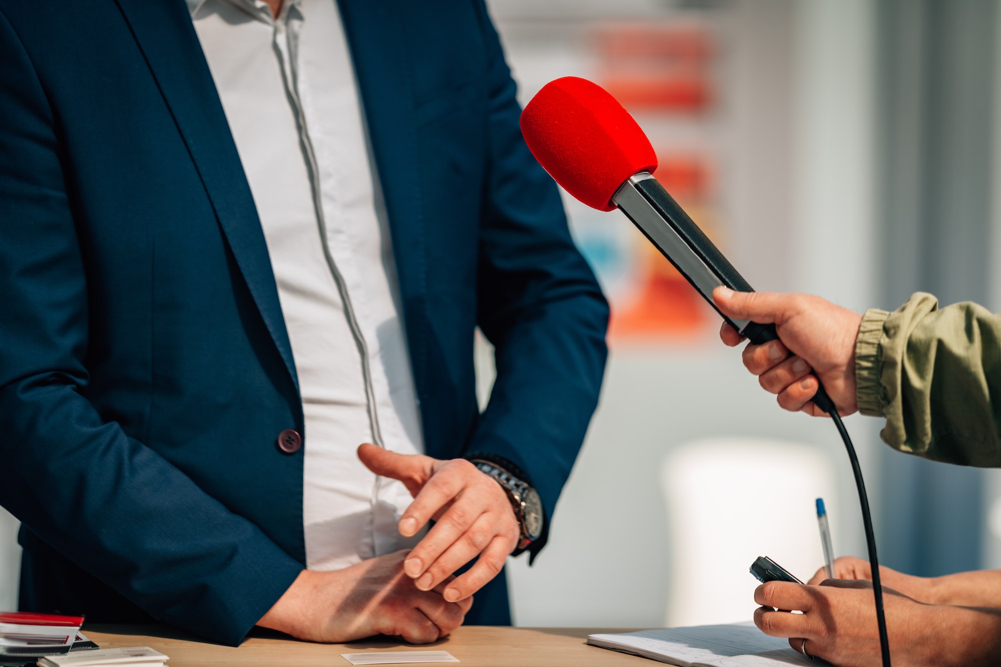 News reporters interviewing a public relations spokesperson.